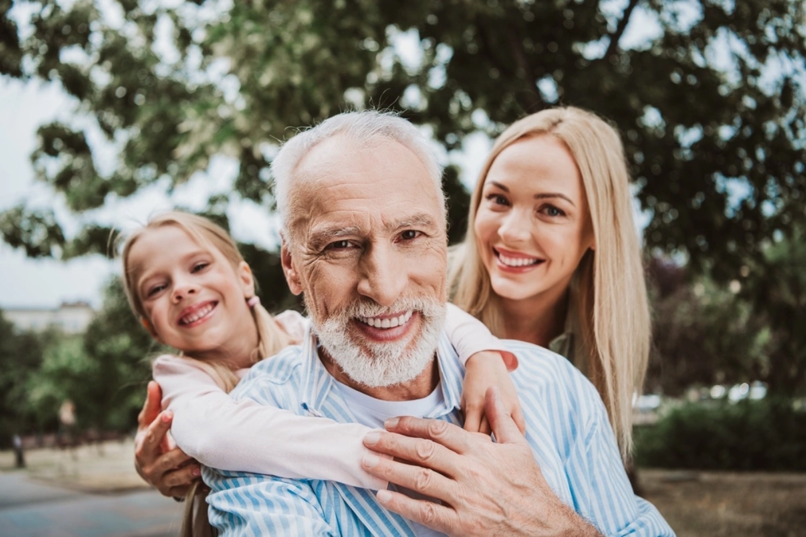 Family smiling comfortably outdoors