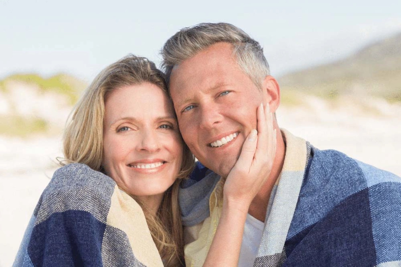 Couple smiling after maintaining their oral health